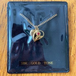 Gold heart necklace with flower and red gemstone